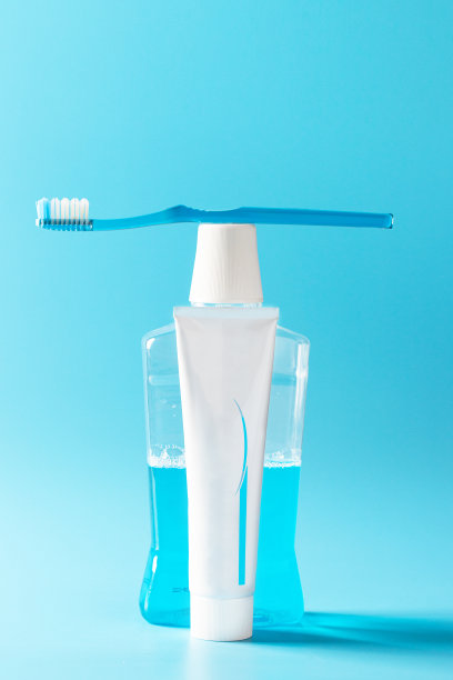 蓝色牙刷，牙膏管和漱口瓶在蓝色的背景上。口腔健康基本护理理念。本空间图片下载