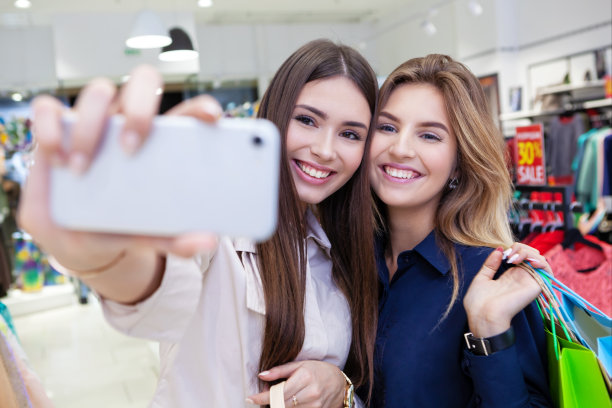 年轻女性外出疯狂购物时自拍。图片下载