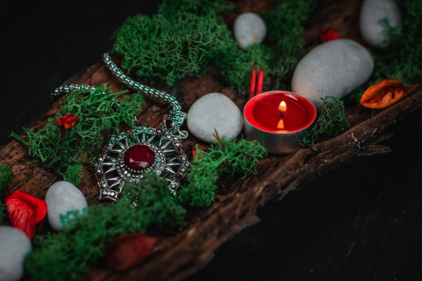 仪式护身符，绿色苔藓，蜡烛，干花和石头树皮黑色。图片下载