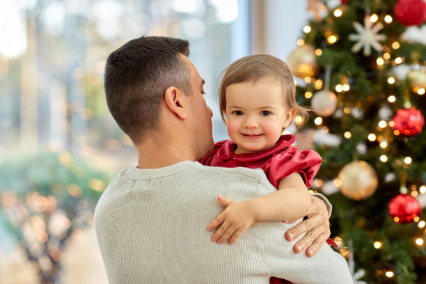 快乐的爸爸和宝贝女儿在圣诞树上图片下载