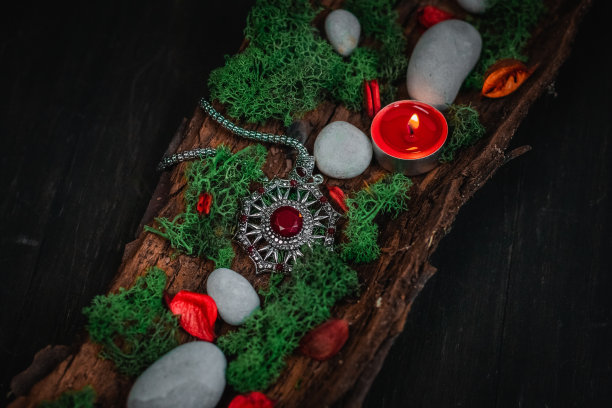 仪式护身符，黑色背景下树皮上的青苔和石头。图片下载