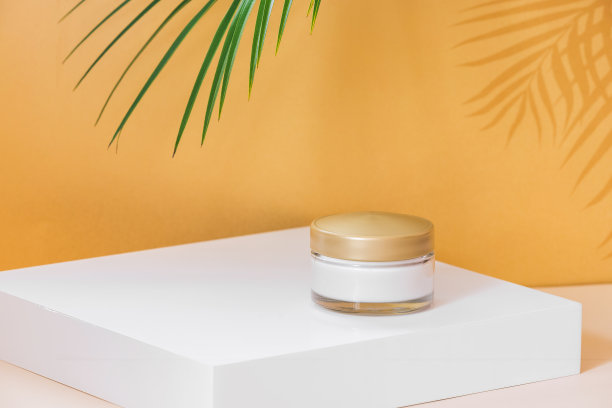 豪华皮肤保湿霜。面霜皮肤护理化妆品放置在白色基座基座与棕榈叶和阴影覆盖图片下载