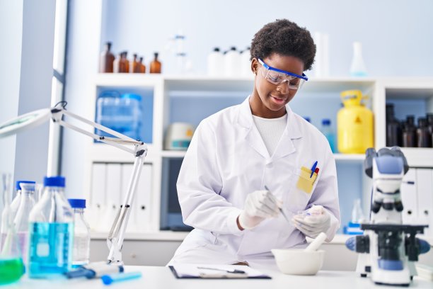 非洲裔美国妇女穿着科学家制服在实验室工作图片下载