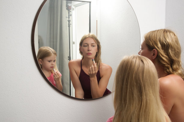 母女俩在镜子前涂口红图片下载