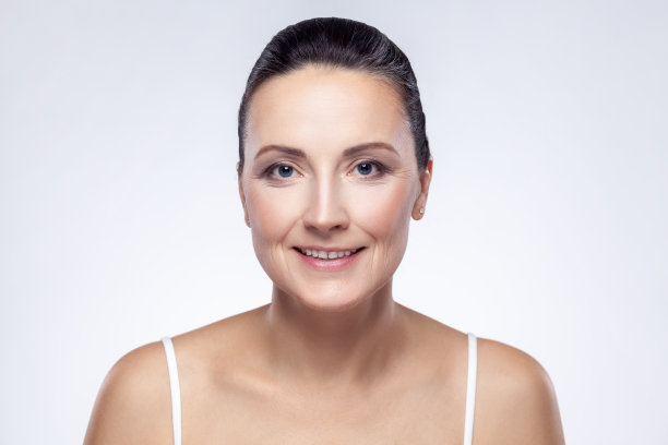 美丽迷人的中年女性完美的皮肤微笑后，面霜，香脂，面膜。图片下载