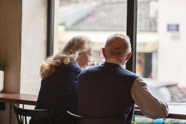 老两口坐在咖啡店的窗边，边聊边喝咖啡图片下载