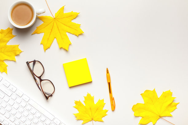 桌面。键盘杯上的咖啡，秋天的枫叶。俯视图图片下载