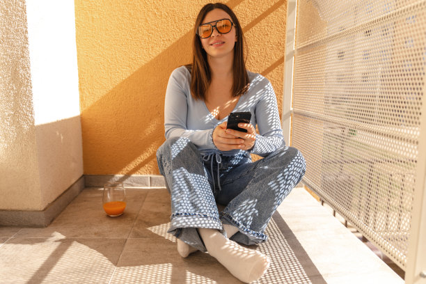 全景可爱微笑的女人在阳台墨镜看相机图片下载