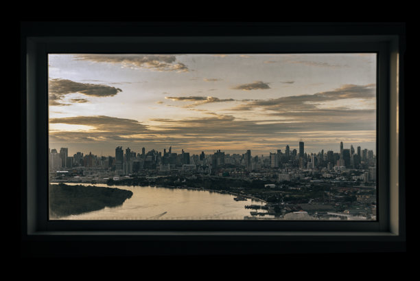 傍晚时分，湄南河沿岸的摩天大楼。透过卧室的窗框看。曼谷的美丽景色，图片下载