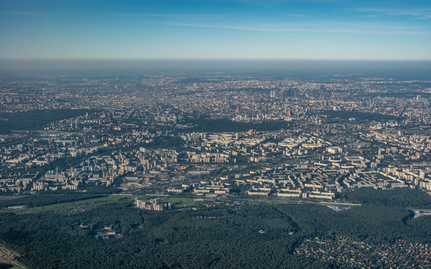 从飞机上鸟瞰城市和晴朗的天空。从飞机窗口拍摄的大城市航拍照片。从飞机上的窗户可以看到城市的景色图片下载