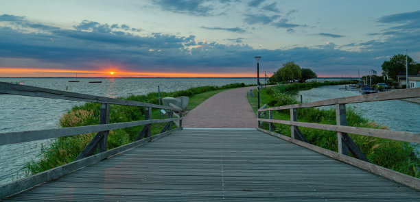 日落时分，作为湖边长廊的一部分的桥图片下载