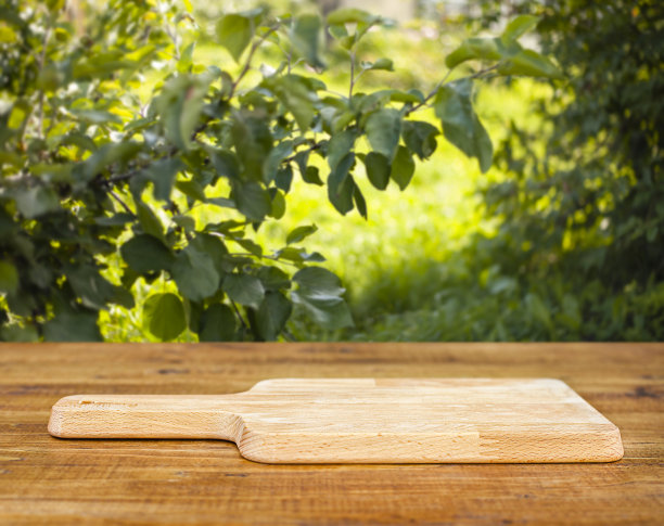 以苹果园为背景的木桌上的砧板图片下载