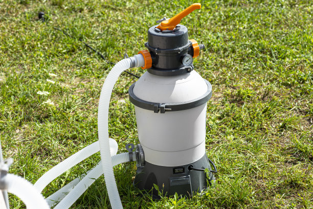 大型砂泵用于花园水池水净化，透明水管可视。图片下载