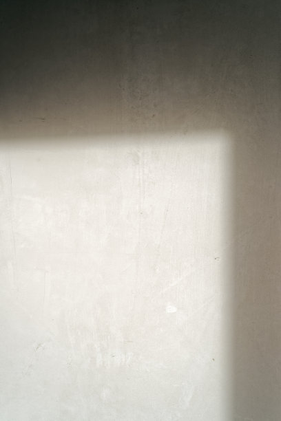 准备翻新的新房间内的墙壁。从窗户斜射进来的光线照在墙上。图片下载