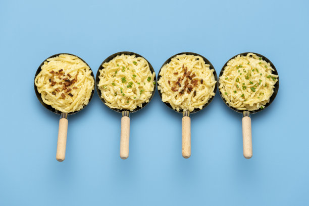 蓝色桌子上的铁锅里放着奶酪面。烤洋葱面饼图片下载