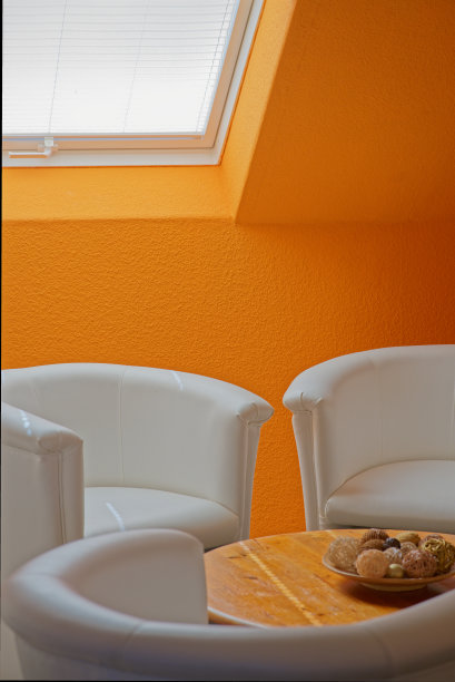 白色的鸡尾酒扶手椅和橙色的木片墙图片下载