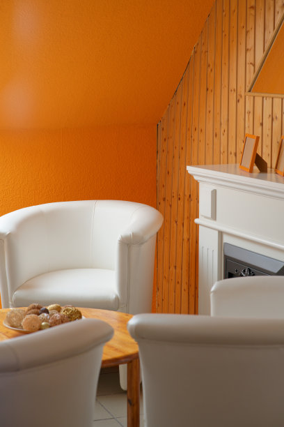 白色的鸡尾酒扶手椅和橙色的木片墙图片下载