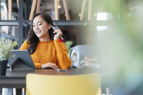 亚洲女性聪明的企业家坐在工作使用平板设备库存管理和检查产品库存在家具陈列室，亚洲女性微笑开朗的企业主在家具店工作图片下载