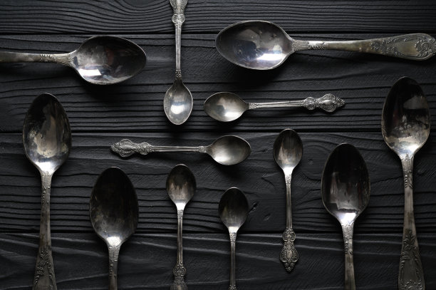 正上方是一张黑色的桌子上一堆旧勺子图片下载