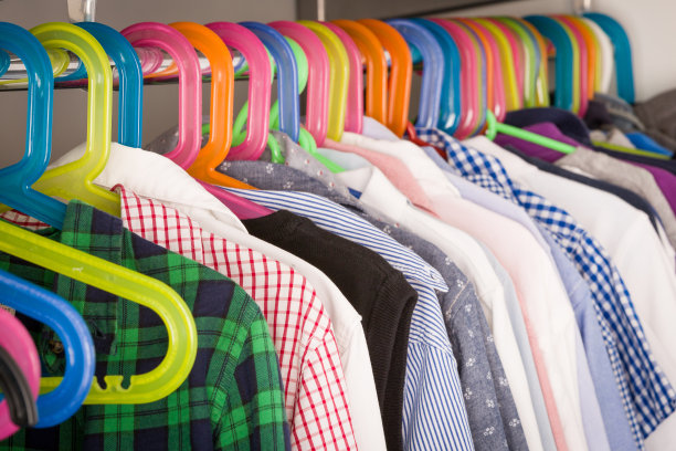 孩子们的衣服挂在房间的衣架上。衣柜里挂着男孩的衣服。购物与消费主义观念。衣服挂在衣架上的梳妆台。五彩缤纷的孩子衣橱。图片下载