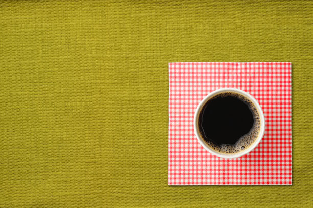 咖啡装在纸杯里，铺在绿色桌布上图片下载