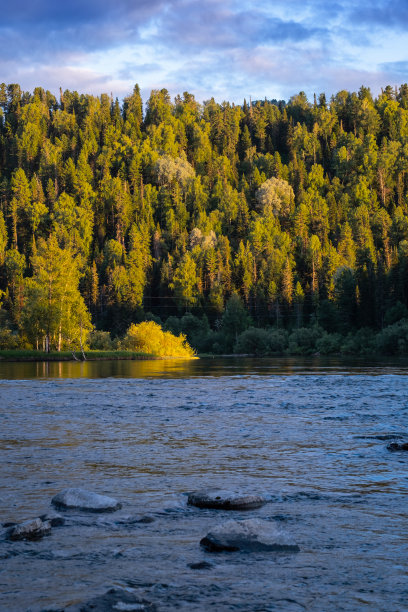 美丽的山河与森林河岸在夕阳辉映在水面上。自然的壁纸。图片下载