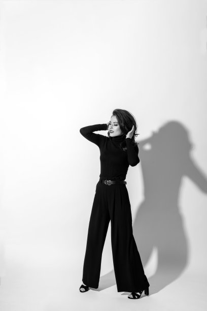 在白色背景上的黑衣工作室肖像的女人图片下载