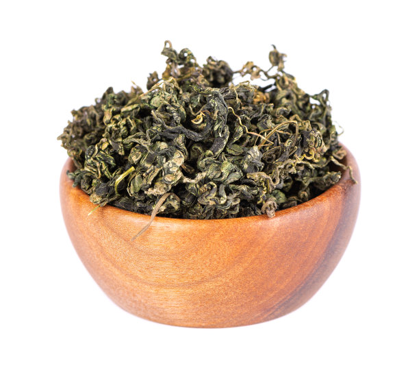 干燥绞股蓝叶在木碗里，离生在白色黑土上。焦谷兰或奇迹草。中国花草茶。图片下载