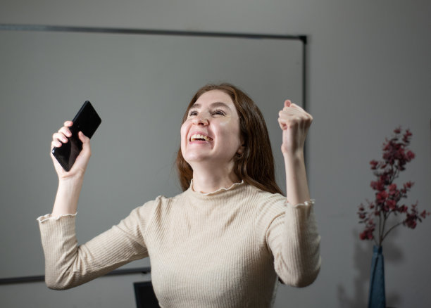 兴奋的红发女孩和智能手机图片下载