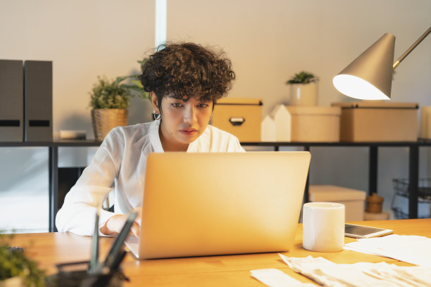 在店里工作的女人。她穿着便服，在网上接受新订单，并为客户包装商品图片下载