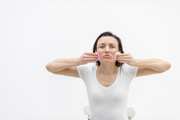 照片的女人与干燥的皮肤触摸她的脸在白色的背景。图片下载