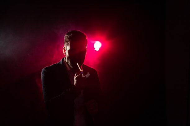 照片上的男人带着香烟和粉红色的烟雾。图片下载