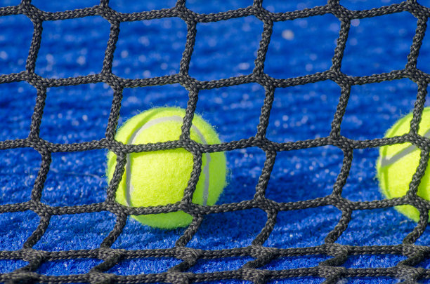 网球:网子后面的球拍场上的球球拍运动图片下载