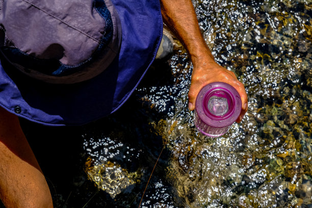 充满冒险精神的男子从小溪中注水图片下载