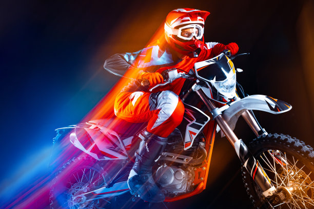 年轻人的肖像，骑摩托车骑摩托车孤立在黑色背景霓虹灯混合灯。速度发展。图片下载