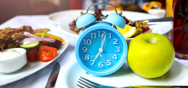 蓝色闹钟间歇性禁食八小时喂食窗口概念和健康饮食背景图片下载