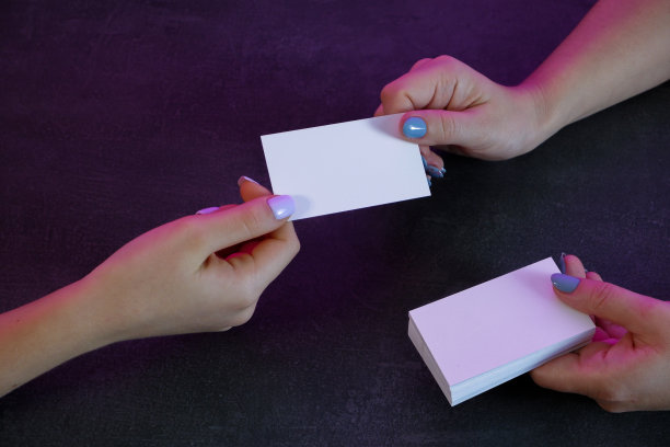 交换名片的商务女性。手的特写。灰石的背景。图片下载