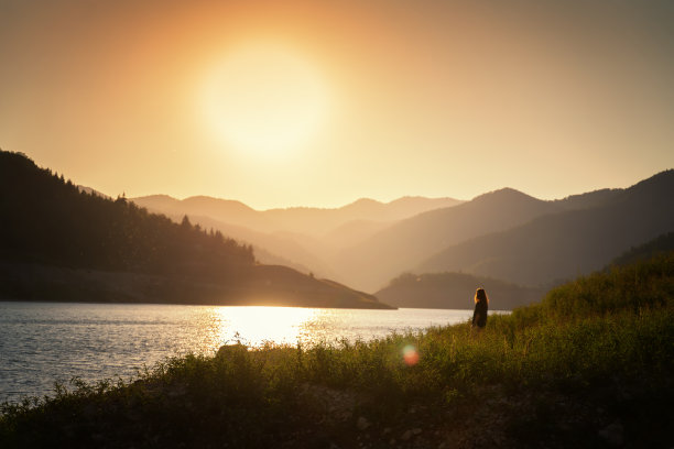 女旅行者在山中的湖岸欣赏日落。塔拉国家公园，前往塞尔维亚图片下载