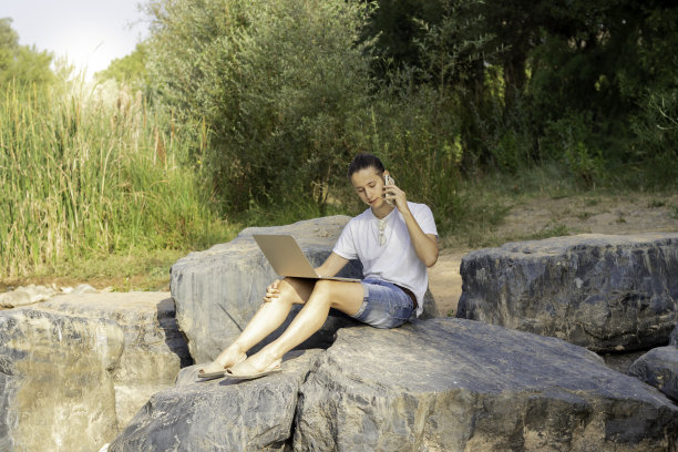 忙碌的企业家一边打电话，一边在大自然中度假，经营着他的数字业务图片下载