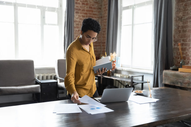 严肃的非洲女商人在现代办公室整理文件图片下载
