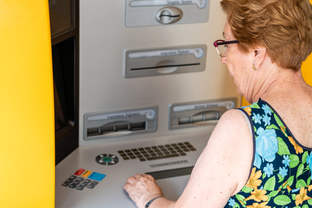 使用自动取款机的老太太的后视图图片下载