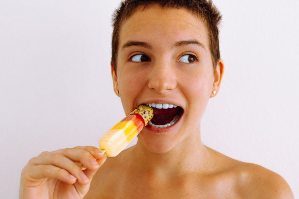 迷人的少年以冰棒的形式展示冰冻果汁图片下载