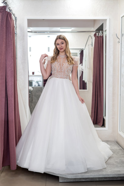 幸福的女人在婚礼沙龙试穿优雅的婚纱图片下载