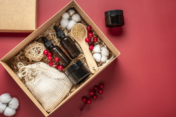 环保化妆品油瓶和奶油瓶，用于洗涤的刷子，红色背景的棉垫送给女朋友的礼物，母亲庆祝圣诞节的概念俯视图平面布局图片下载