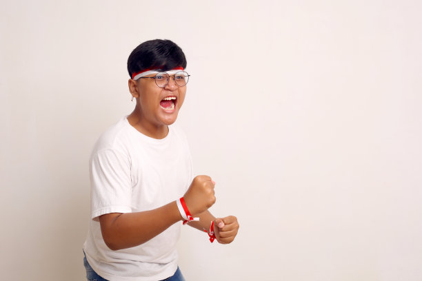 热情的亚洲男孩站着，紧握双手，尖叫。隔离在白色与copyspace图片下载