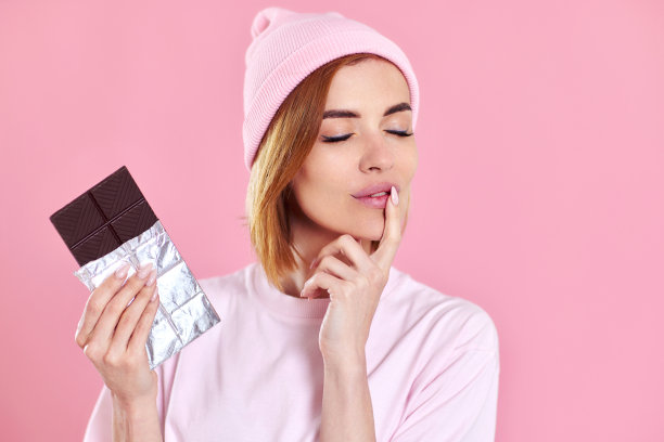 女人享受黑巧克力粉嫩的背景图片下载