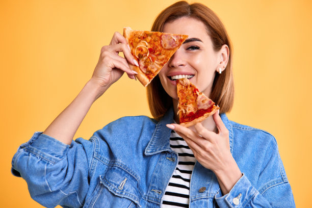 女人用一片新鲜的披萨遮住眼睛图片下载