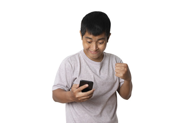 年轻人用胜利者的手势谈论智能手机，庆祝胜利的快乐。图片下载