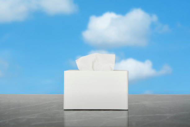 在天空背景的桌子上擦拭纸巾盒或纸巾盒图片下载