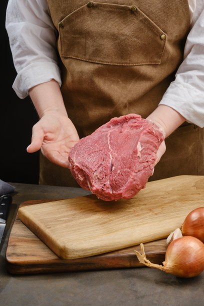 厨师展示了一块木板下的牛肉片。图片下载